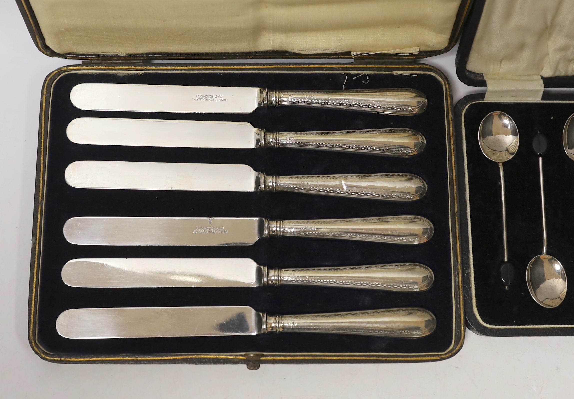 A cased set of six 1930's silver bean end coffee spoons, Birmingham, 1931 and a cased set of six handled tea knives.